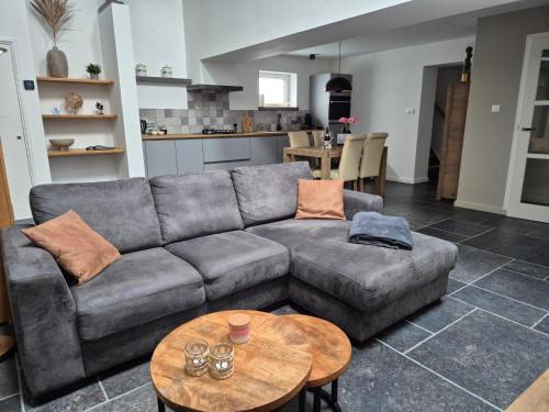 a living room with a couch and a table at Gastenverblijf Oesj in Eijsden