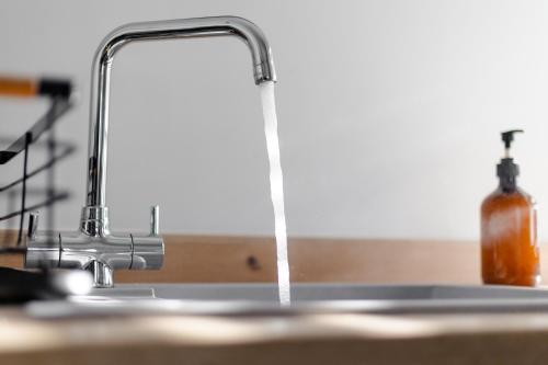 eine Küchenspüle mit Wasser aus einem Wasserhahn in der Unterkunft Bespoke Apartments Near Cardiff City Centre Free Parking in Cardiff
