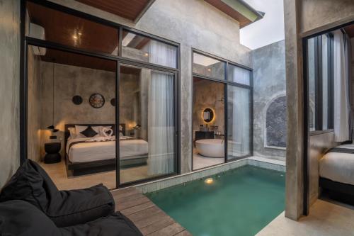 a bedroom with a swimming pool and a bedroom with a bed at Nauti Villa in Ubud