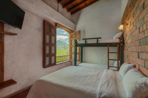 a bedroom with a bunk bed and a window at Granja del Cafe Hotel y Centro de convenciones in Venecia