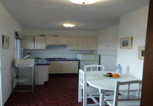 a small kitchen with a white table and chairs at Acogedor Apartamento en Puerto Estaca in Puerto de la Estaca