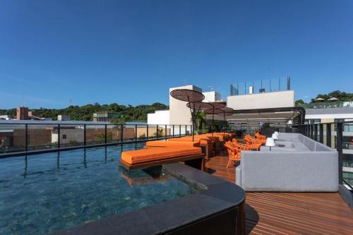 ein Balkon mit einem Swimmingpool auf einem Gebäude in der Unterkunft Bless Hospedagem - Flat 117 premium beira mar de cabo branco in João Pessoa