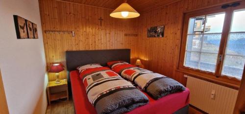 a red couch in a room with a window at Narcisse 15 in Champoussin