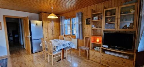 a dining room with a table and a television at Narcisse 15 in Champoussin