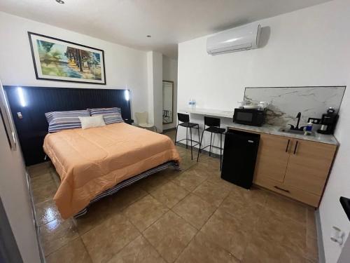 a bedroom with a bed and a kitchen in it at Estudios 303 in San Juan