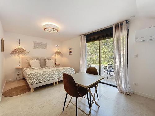 una camera da letto con un letto e un tavolo con sedie di La villa dans les arbres - Triangle d'or du Luberon a Ménerbes