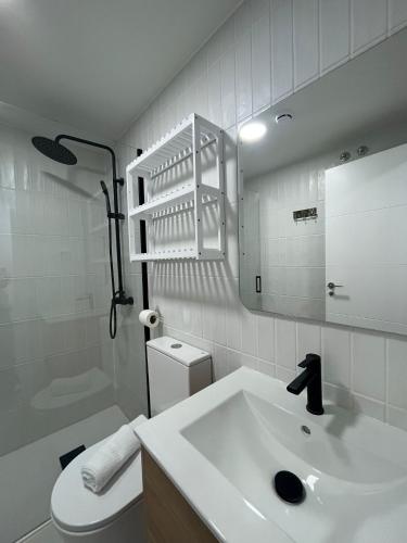 a bathroom with a sink and a toilet and a mirror at A&R Atico Duplex Luxury II in San Sebastián de los Reyes