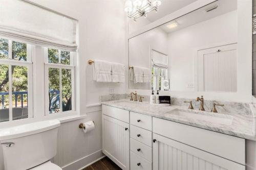 a white bathroom with two sinks and a large mirror at The Last Waltz in Seacrest
