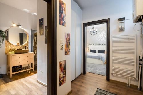a hallway with a bedroom with a bed and a mirror at Hotel Avner in Bucharest
