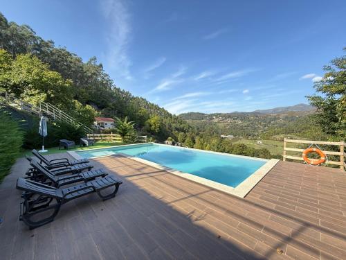 a swimming pool with two lounge chairs on a wooden deck at WildValley Guesthouse in Braga