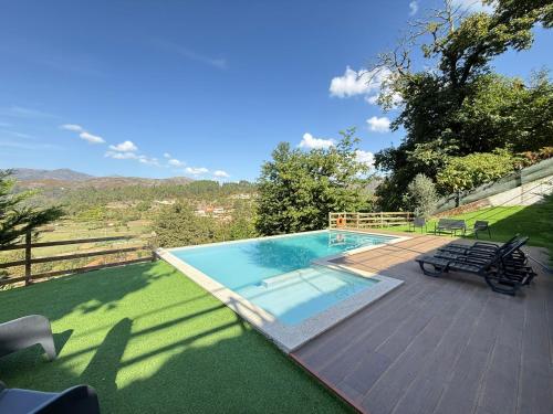 a swimming pool with a deck and chairs next to it at WildValley Guesthouse in Braga