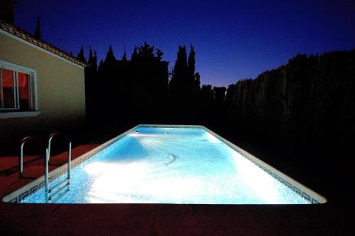 a swimming pool lit up at night in front of a house at La casa de las golondrinas in Tángel