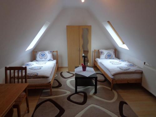 Zimmer im Dachgeschoss mit 2 Betten und einem Tisch in der Unterkunft Haus in der Nähe von Hannover Messe in Hannover