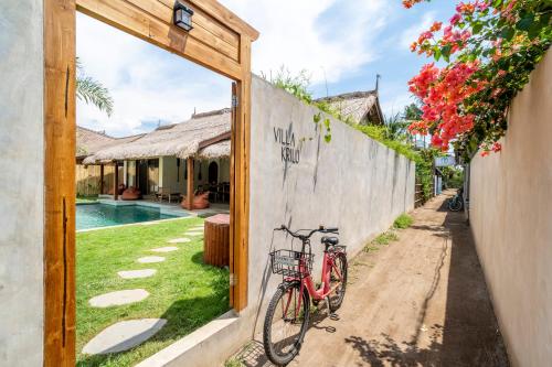 Ein Fahrrad, das an einer Mauer neben einem Hof geparkt ist. in der Unterkunft Villa Krilu - Spacious private 2-bedroom & pool in Gili Air