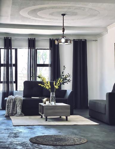 a living room with a blue couch and a table at ED Holiday Home- Chobe in Lesoma