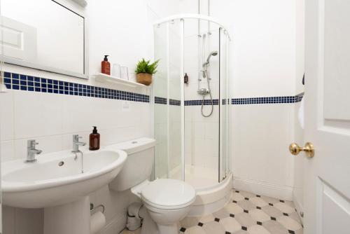 a bathroom with a toilet sink and a shower at Stable House in Redruth