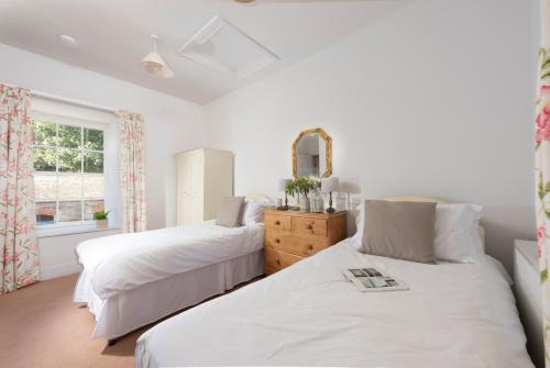 a bedroom with two beds and a window at Stable House in Redruth