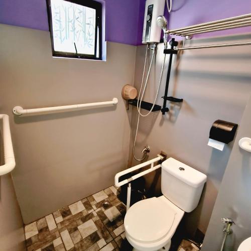 ein Badezimmer mit Toilette und Fenster in der Unterkunft DK's Inn in Coron