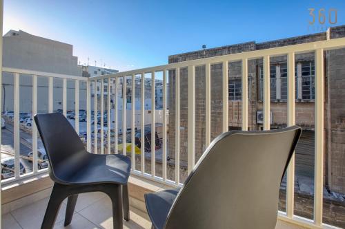 2 stoelen op een balkon met uitzicht op de stad bij Central 2BR Home in Pieta's Heart with Wifi & AC by 360 Estates in Pieta