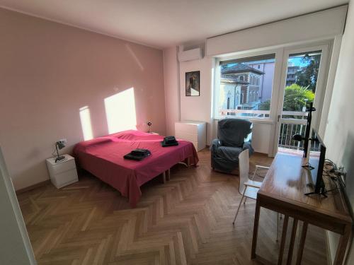 Un dormitorio con una cama roja y una silla. en Bagaini Urban Flat, en Varese