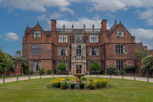 a large brick building with a fountain in the yard at Castle Bromwich Hall Hotel, BW Signature Collection by Best Western in Birmingham