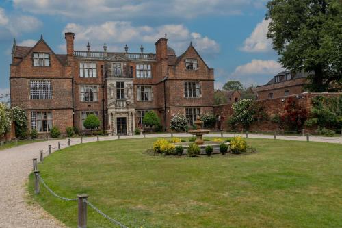 a large brick building with a park in front of it at Castle Bromwich Hall Hotel, BW Signature Collection by Best Western in Birmingham
