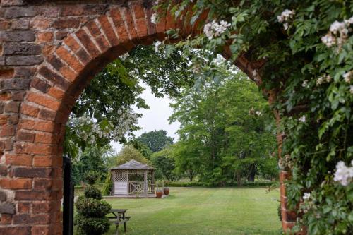 an archway leading into a garden with a gazebo at Castle Bromwich Hall Hotel, BW Signature Collection by Best Western in Birmingham