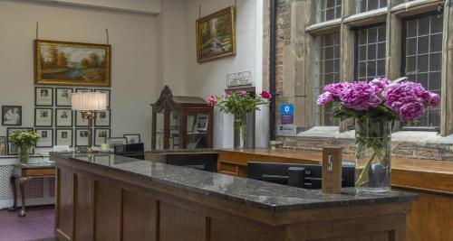 a vase of purple flowers sitting on a counter at Castle Bromwich Hall Hotel, BW Signature Collection by Best Western in Birmingham