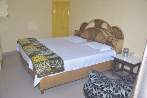 a bedroom with a large bed and a table at Sahil cottage in Chamba