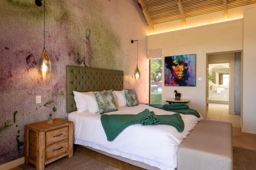 a bedroom with a large bed and a purple wall at Kunjani Villas & Wines in Stellenbosch