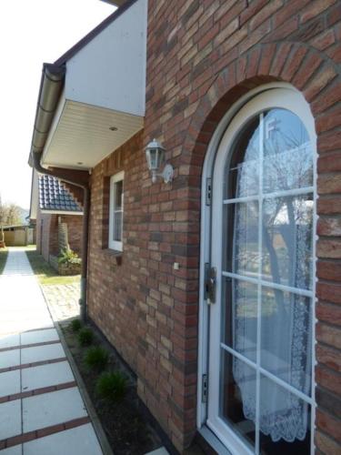 a brick building with a door with a window at Giebelhaus Frida in Süderende
