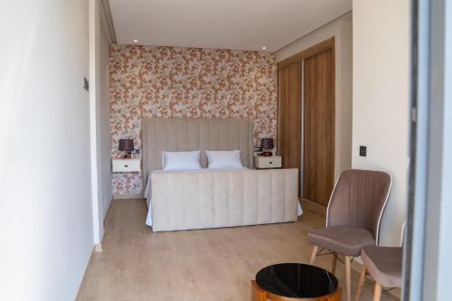 アガディールにあるAgadir Bay Dream Stayの花柄の壁紙を用いた白いベッドが備わるベッドルーム1室