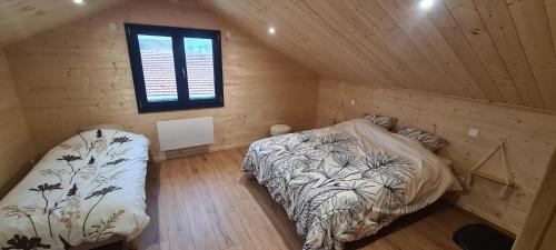 a bedroom with two beds in a wooden cabin at Gîtes des Deux Sapins 