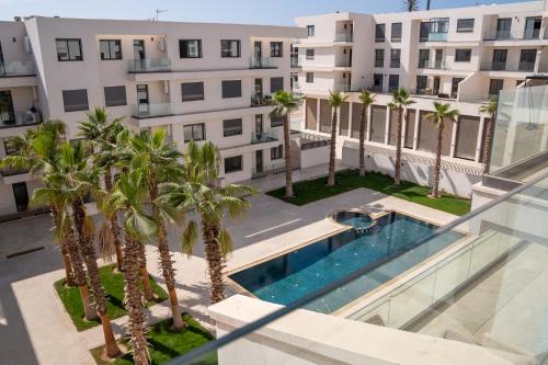 アガディールにあるAgadir Bay Dream Stayのヤシの木が茂るアパートメントビル