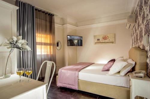 ローマにあるRome Visitsのベッドルーム1室(ベッド1台、ワイングラス付きのテーブル付)