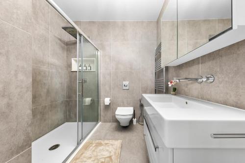 Un baño con bañera blanca y un inodoro. en The Ridge Residence - Luxury 4 Bed Near Warner Bro Studios With Parking, en Leavesden Green