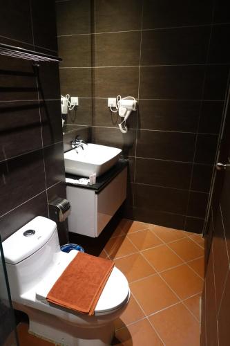 une salle de bain avec des toilettes blanches et un lavabo dans l'établissement MM Heritage Hotel, à Malacca