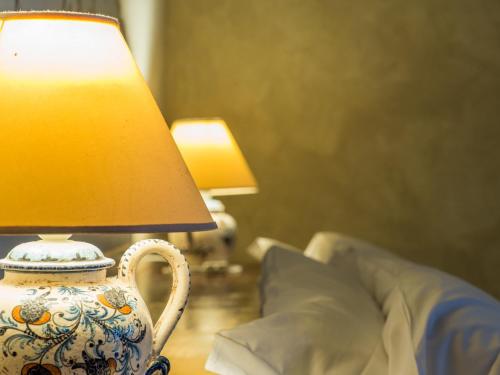 a blue and white vase sitting on a table with a lamp at Le Silve di Armenzano in Assisi