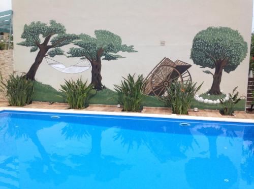 a mural of trees next to a swimming pool at Le Torri Villas by Nidri holiday villas in Nydri