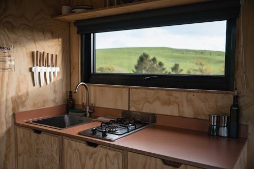 a kitchen with a sink and a window above a stove at Ascella in Llanrwst