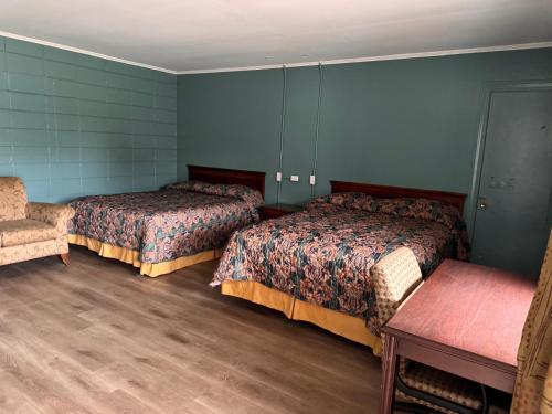 a room with two beds and a chair in it at Walkers Inn by Hotel O Dothan US 84 in Dothan