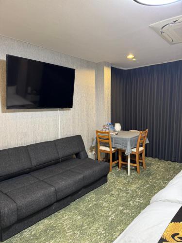 a living room with a couch and a table with chairs at Shiba inn in Tokyo