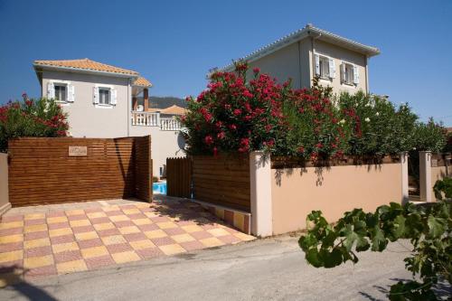 a house with a fence with flowers on it at Le Torri Villas by Nidri holiday villas in Nydri