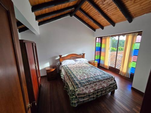 a bedroom with a bed with a colorful blanket at Hospedaje Casa Arte con Aroma de café in Duitama
