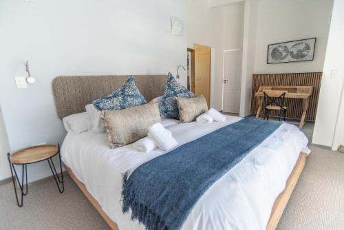 a large bed with blue and white pillows on it at Waterfront Estate F13 Swakopmund in Swakopmund