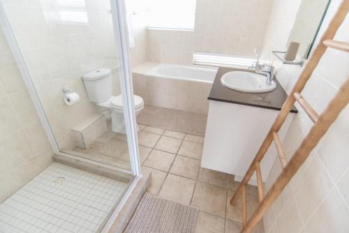 a bathroom with a shower and a toilet and a sink at Waterfront Estate F13 Swakopmund in Swakopmund