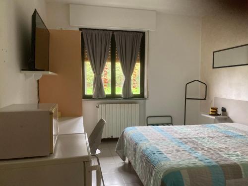 a bedroom with a bed and a window at La Locanda Di Perico Paola in Veruno