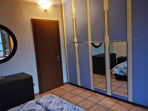 Ein Schlafzimmer mit einem verspiegelten Kleiderschrank, einem Bett und einem Spiegel in der Unterkunft Cusani 34 in Carate Brianza
