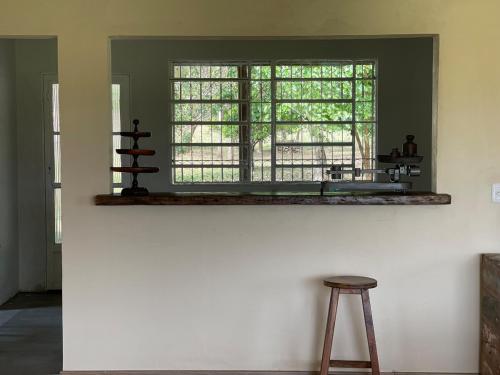 a window in a room with a stool in front of it at Casa aconchegante ao lado do Parque de Exposições in São Borja