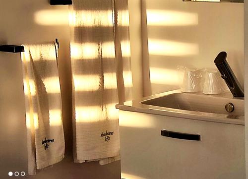una cocina con toallas blancas y un fregadero en atardeceres lofts, en Benaocaz